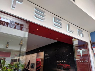 Honolulu - 31 Mayıs 2018: Gri yazılı beyaz Tesla tabelası, Ala Moana Alışveriş Merkezi 'ndeki Tesla mağazasının üzerinde gururla duruyor..