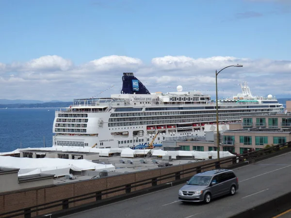 シアトル 2016年6月25日 宝石というノルウェーのクルーズ船がワシントン州シアトルの港に停泊し バンは前方の高速道路を走行しています 船は世界で最大かつ最も豪華なクルーズ船の一つです — ストック写真