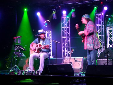 Honolulu - 2 Mayıs 2017: Müzisyenler Tavana ve Tommy gitar çalmak ve Sahne Alanı'nda Hawaiian Brian'ın Kavşağı'nda 3 Mayıs 2017 üzerinde serin aydınlatma ile Honolulu, Hawaii şarkı Osuna.