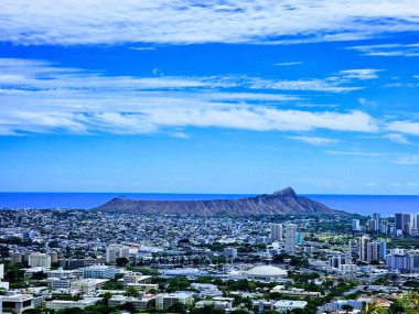 Bir hava görüntüsü Honolulu 'nun hareketli şehir manzarasını yakalıyor. Simgesel elmas başlıklı krater canlı metropolün başında nöbet tutuyor..
