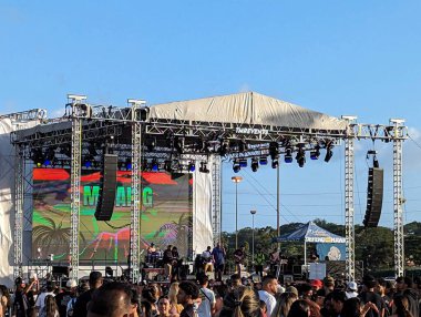 Honolulu - 28 Temmuz 2023: Micah G, Aloha Stadyumları açık hava mekanında sahneye çıkıyor. Kalabalık onun duygusal melodilerinin ritmine göre sallanıyor, yüzleri sahne ışıklarının sıcacık parıltısıyla aydınlanıyor. Okyanus esintisi onun melodik sesini taşırken.