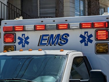 Honolulu - 20 Nisan 2023: Kentsel bir ortamda acil durum ışıkları olan bir EMS ambulansının önü.