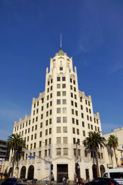 Hollywood - 23 Ocak 2014: Yüksek bir sanat deco binası açık mavi gökyüzü altındaki canlı bir şehir sokağına hakim oldu.