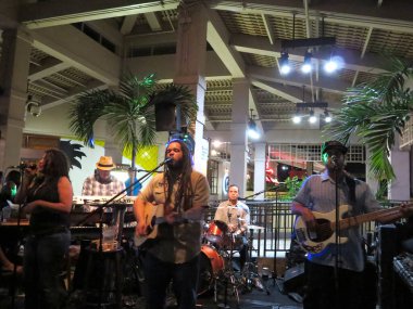 Honolulu, Hawaii - 10 Ocak 2014: Rehberlik grubu Ala Moana Alışveriş Merkezi 'ndeki Mai Tai Bar' da gitar ve davul çalıp şarkı söylüyor..