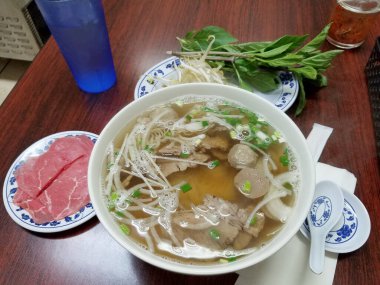 Honolulu - 14 Ağustos 2017 Biftek dilimleri, otlar ve fasulye filizi ile bir kase Vietnamlı pho yemeye hazır..