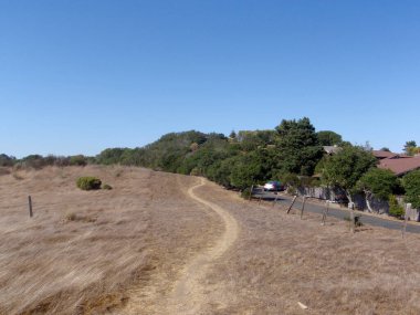 Kaliforniya - 24 Eylül 2008: Sakin bir patika kuru bir tarladan yeşil tepelere doğru ilerliyor