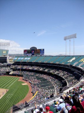 Oakland - 10 Haziran 2010: Taraftarlar Oakland Kolezyumu 'nda açık mavi gökyüzü altında heyecanlı seyircilerle dolu bir beyzbol maçının keyfini çıkarıyorlar..