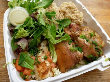 İçinde tavuk, esmer pirinç, salata ve yeşil soğan bulunan klasik bir Hawaii tabağı..