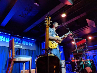 Waikiki - November 29, 2017: Ron Artis II performs live on stage at Blue Note Hawaii in Waikiki. The musician plays the keyboard while another musician plays the drums in the background. clipart