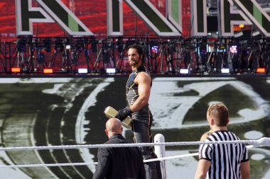 Santa Clara, California - March 29, 2015: WWE Wrestler Seth Rollins holds Money in the Bank Briefcase turnbuckle before match in the ring at Wrestlemania 31 at the Levi's Stadium. clipart