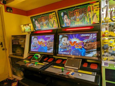 Pearlridge - 11 Ağustos 2023: Oyuncular Oahu, Hawaii 'deki bir atari salonunda Street Fighter III oynarken yoğun rekabetin keyfini çıkarıyorlar. Renkli ekranlar ve nostaljik oyunlar canlı bir atmosfer yaratır..