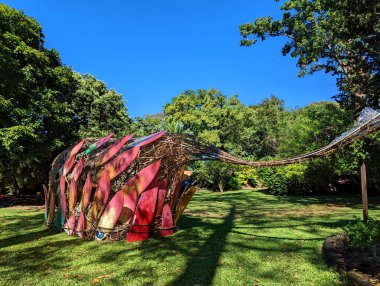 Honolulu - 3 Şubat 2022: Foster Garden 'da canlı sörf tahtalarının yer aldığı eşsiz bir sanat kurulumu, Oahu' da parlak bir günde yeşilliğin ortasında yaratıcılık sergiliyor..