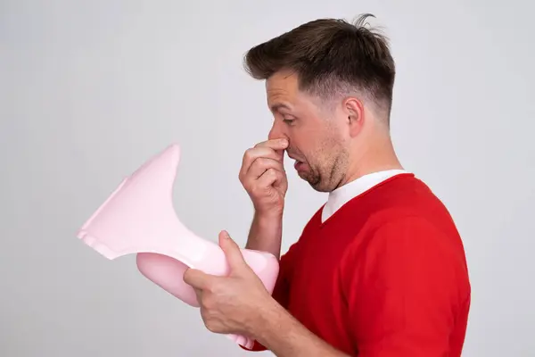 stock image Disgusted caucasian man smell his son potty. Everyday parents chores. Studio shot