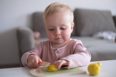 Sanat ve zanaat sınıfında plastikle çalışan gülümseyen küçük çocuğun portresi. 