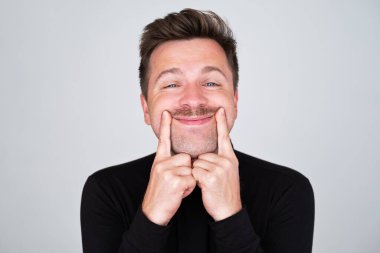 Depresyondaki kötü ruh hali yerine gülümsemeye çalışan yakışıklı genç adam.. 