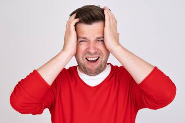 Endişeli adam, ellerinin arasında endişeli görünüyor. Endişe kavramı, geri çevrilemez hata, korku hissi. 