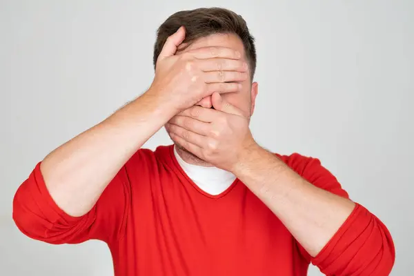 stock image Shy caucasian man hiding his face trying to stay anonym.. Concept of being shy. 