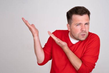 Şüpheli bir adam köşeden işaret eder, bir konuda tereddüt hisseder, dudaklarını şaşkınlıkla doldurur. Reklamcılık ve insanların konsepti.