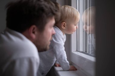 Küçük kızıyla babası pencereye bakıyor ve birini görmeyi bekliyor. Evden sokağa bakan bir çocuk. Ailecek vakit geçirmek.. 