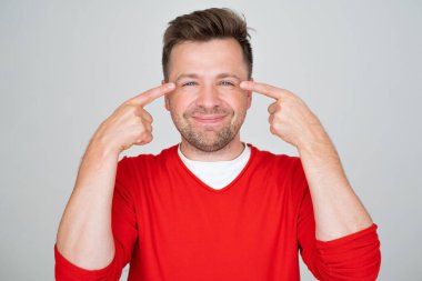 Sağlık konsepti. Gülümseyen genç yakışıklı adam, ameliyattan sonra gözleri iyi görüyor.. 