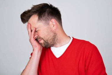 Kafkasyalı bir adam başının ne kadar ağrıdığını gösteriyor. Acı çekiyor, perişan ve bitkin görünüyor.. 