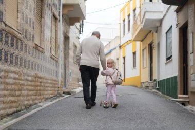 Bir büyükbaba, 3 yaşındaki torunuyla motosiklete biniyor ve onu anaokuluna götürüyor..