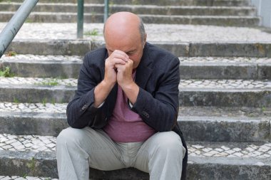 Açık Merdiven 'de oturan yaşlı İspanyol Adam Düşüncede Kaybolmuş, Yorgun ve Ateşli Hissediyor. Yüksek kalite fotoğraf