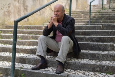 Açık Merdiven 'de oturan yaşlı İspanyol Adam Düşüncede Kaybolmuş, Yorgun ve Ateşli Hissediyor. Yüksek kalite fotoğraf