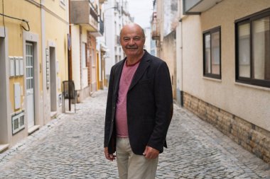 Portekiz 'in Dar Sokaklarında Yürüyen ve Gülümseyen Yaşlı Bıyıklı Adam. Yüksek kalite fotoğraf