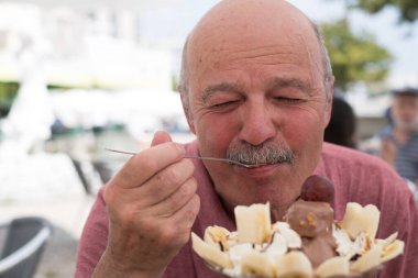 Tatilde Yazın bir kafede dondurma yiyen yaşlı bir İspanyol. Yüksek kalite fotoğraf