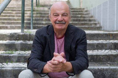 Merdiven basamaklarında oturan, dinlenen ve gençliğini hatırlayan yaşlı adam. Yüksek kalite fotoğraf