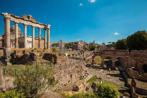 Roman Forum, arches and columns in Rome, Italy. Antique ruins of historical landmarks. Foro romano near the Colosseum and Palatine Hill.