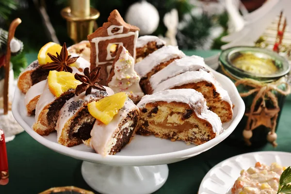 传统的圣诞蛋糕和罂粟籽片放在陶瓷蛋糕架上的节庆桌上 — 图库照片