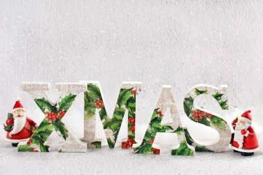 Parlak Noel arkaplanı, ayakta duran XMAS harfleri ve kendi metin alanı olan iki Noel Baba figürü.