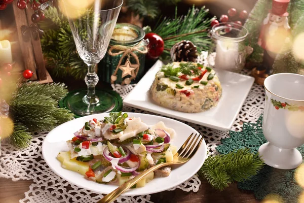 クリスマスのテーブルの上にジャガイモ 玉ねぎ リンゴとサワークリームと2つのニシンのサラダ — ストック写真