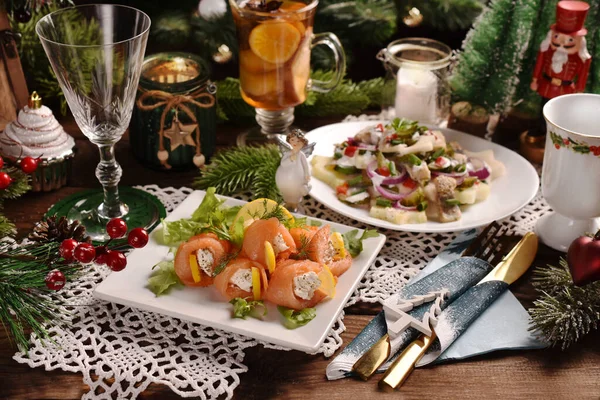 ホースラディッシュチーズとニシンのサラダとサーモンロールポテト 玉ねぎ リンゴとピクルス付きクリスマスイブテーブル — ストック写真