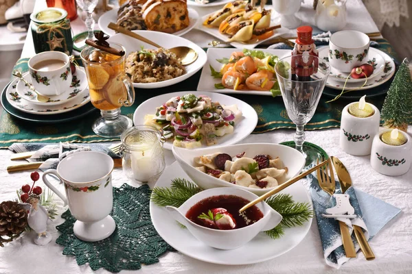 クリスマス イブの赤いボルシチのスープには キノコ入り餃子 ニシンサラダ サーモンロールなどの伝統料理がお祝いのテーブルに並べられています — ストック写真