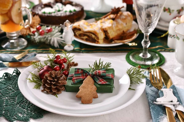 お祝いの装飾が施されたプレートと伝統的なペストリーとドライフルーツコンポート付きのクリスマステーブル — ストック写真