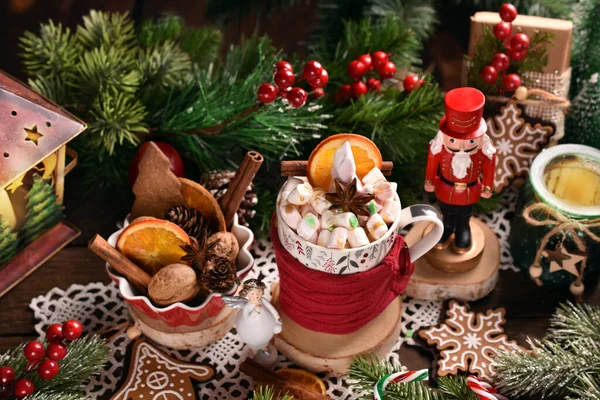 クリスマスコーヒーやホットチョコレートのカップで マシュマロとキャラメルを木製のテーブルに飾ります — ストック写真