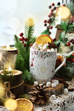 Bir fincan sıcak çikolata, marşmelov ve Noel süslemeleri kırsal bir pencerede duruyor.