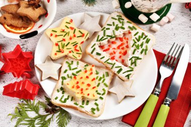 Yıldız ve Noel ağacı şekilli peynirli, jambonlu ve soğanlı sandviçleri olan çocuklar için yaratıcı ve lezzetli bir Noel kahvaltısı. 