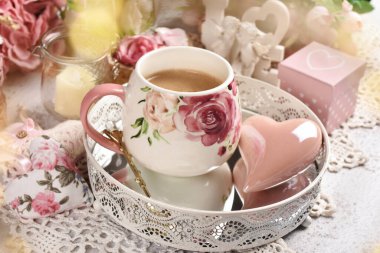 Romantic style coffee and a pink heart on metal tray with a mirror on the table