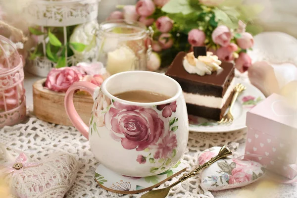 Romantic style coffee and chocolate cake on the table with flowers and love symbol decors