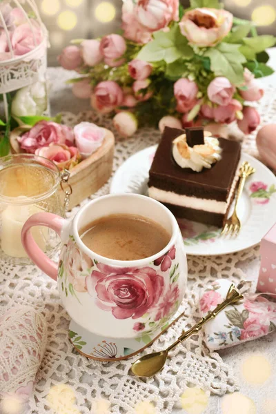 Romantic style coffee and chocolate cake on the table with flowers and love symbol decors