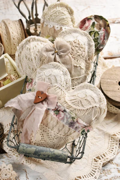 用花边 亚麻布和针织物制成的老式手工心形金属丝筐和木制桌子上的缝纫用品 — 图库照片