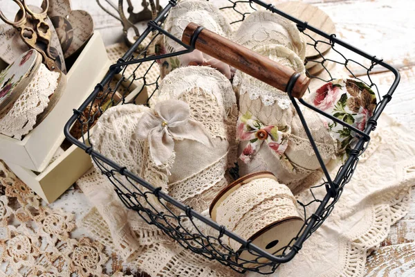 用花边 亚麻布和针织物制成的老式手工心形铁丝筐和木制桌面上的缝纫用品 — 图库照片
