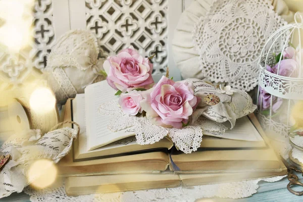 浪漫的风格布置 翻开的旧书 玫瑰和古老的手工艺品心房 放在桌上的枕头 — 图库照片