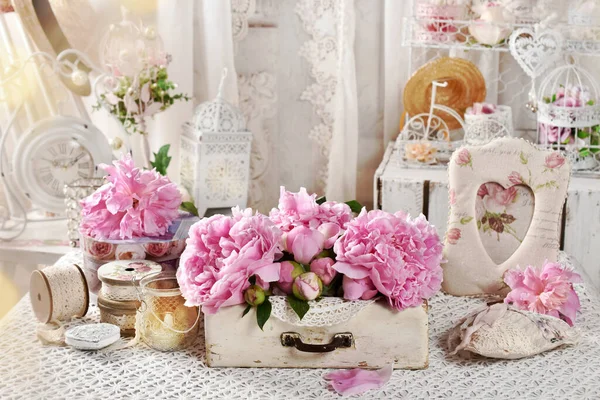 在桌子上的老式木制抽屉里 用粉红色新鲜的牡丹装饰着精致时髦的室内装饰 — 图库照片