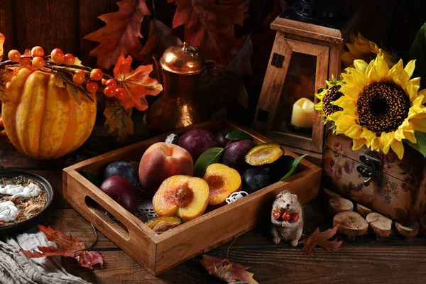 Vintage style autumn still life with seasonal fruits in the box on dark wooden table with decors