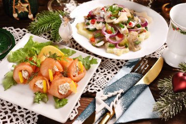 Krem peynirle doldurulmuş füme somon ruloları ve noel masasında ringa balığı salatası.. 
